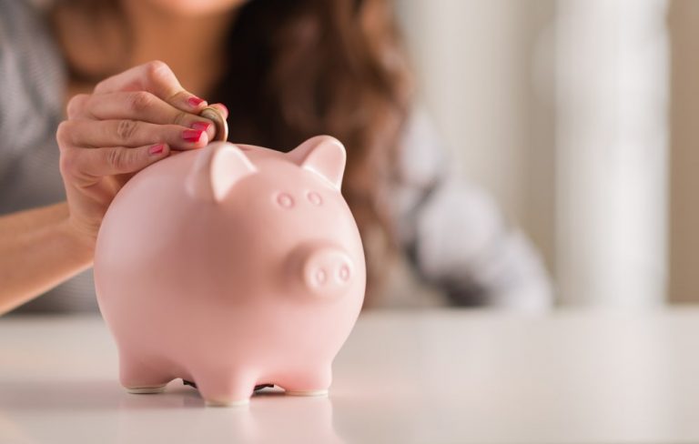 woman putting money into a piggy bank